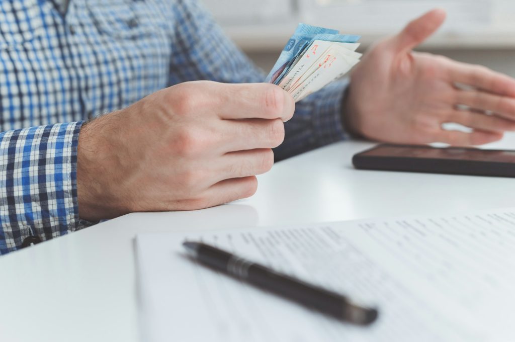 Tough financial conditions. Businessman holds money and gestures specifically