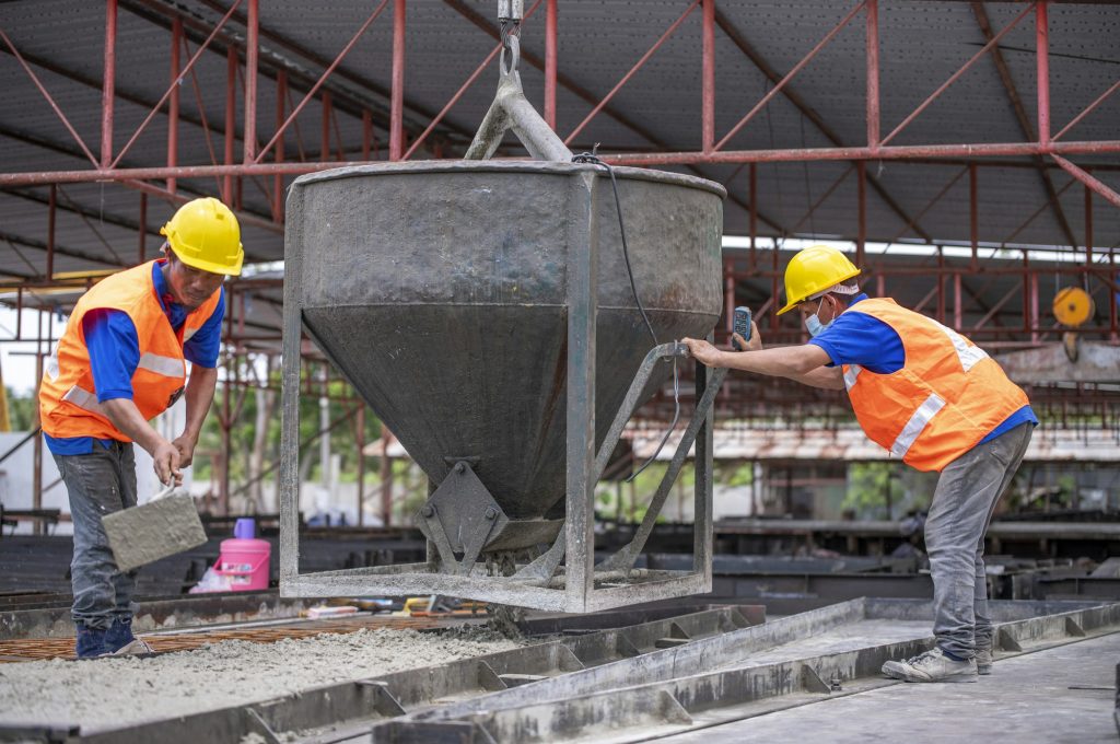 Worker are working at a construction site worker is handling a tool, possibly a trowel, while the ot